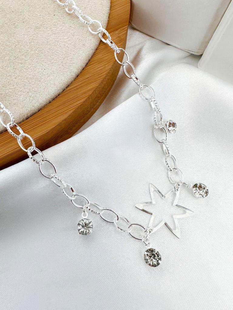 Colar de elo oval com pingente de flor vazada e zircônias.