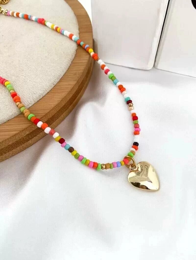 Colar de miçangas com pingente coração dourado