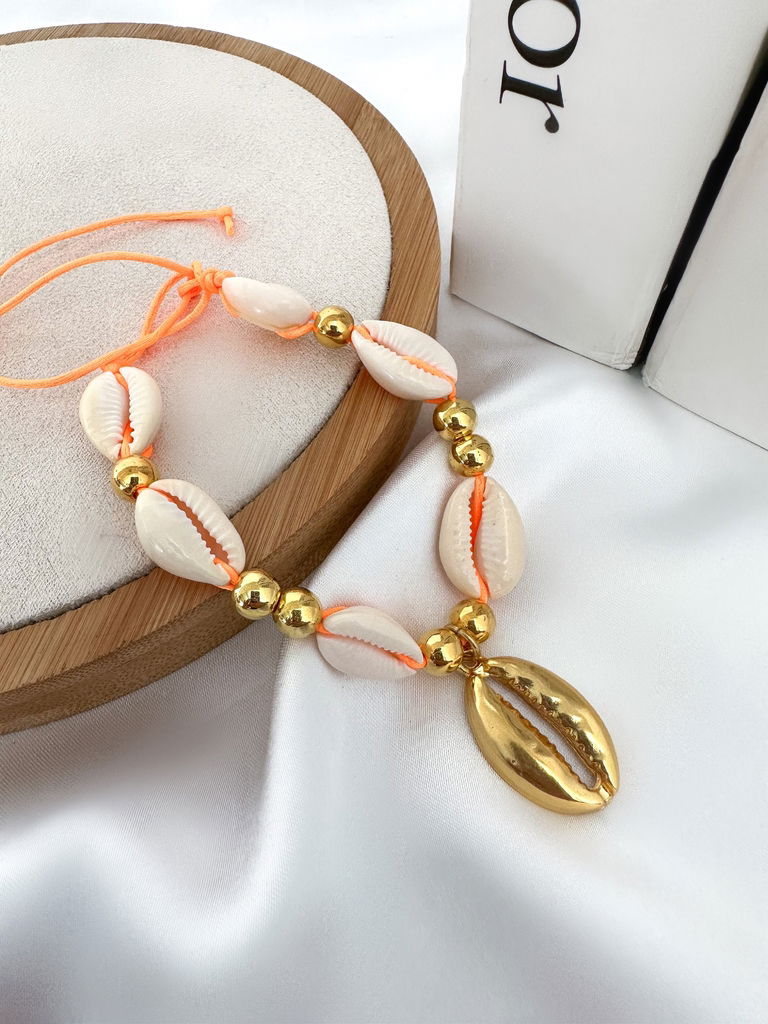 Pulseira de búzios com entre meios de esferas douradas