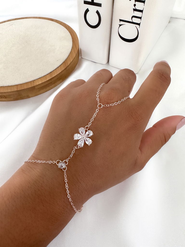 Pulseira de mão folheada com ponto de luz no pulso e flor em navetes