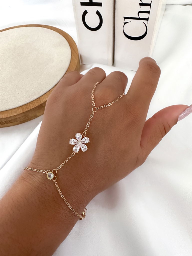 Pulseira de mão folheada com ponto de luz no pulso e flor em navetes