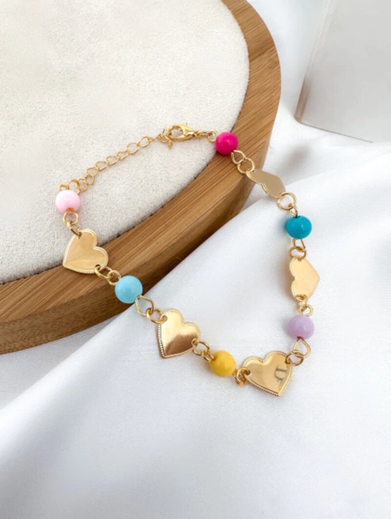 Pulseira folheada a ouro com chapinhas de coração e esferas coloridas.