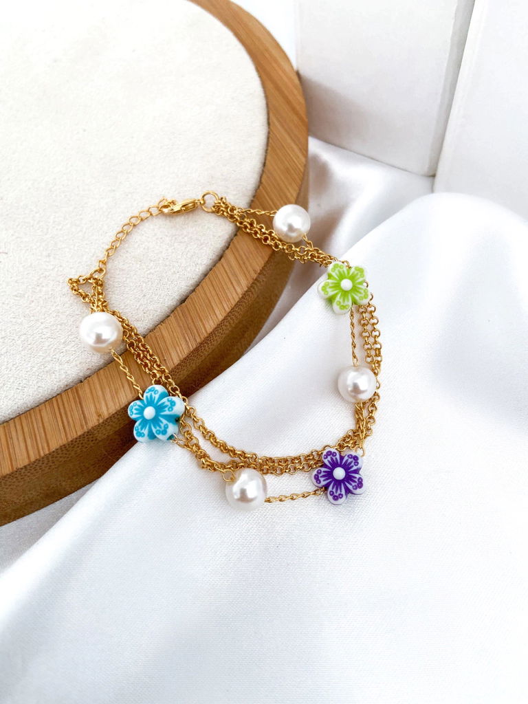 Pulseira três fios folheada a ouro 18k com perolas e flores.